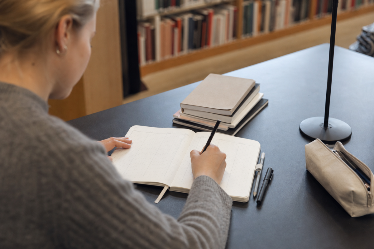 Student ritar veckouppslag i en prickad bok